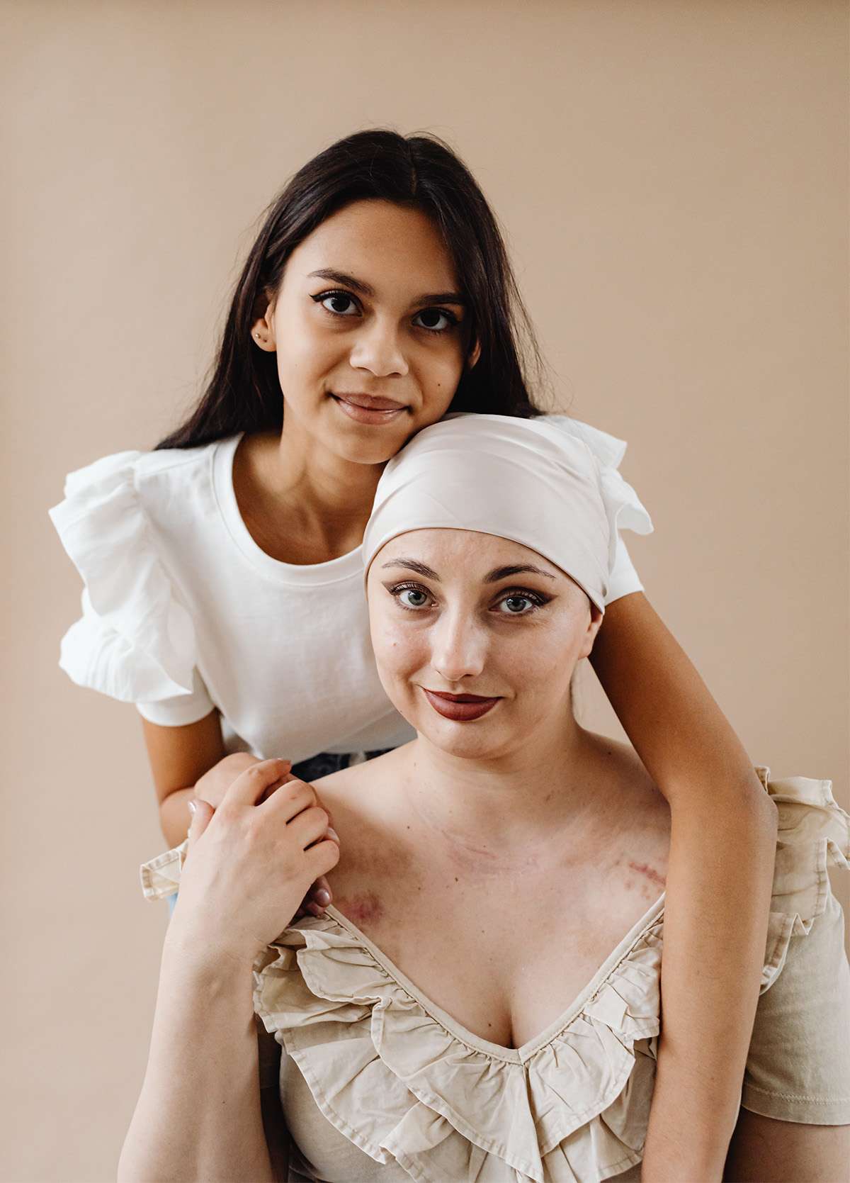 two women looking at camera after one of them received cancer treatment