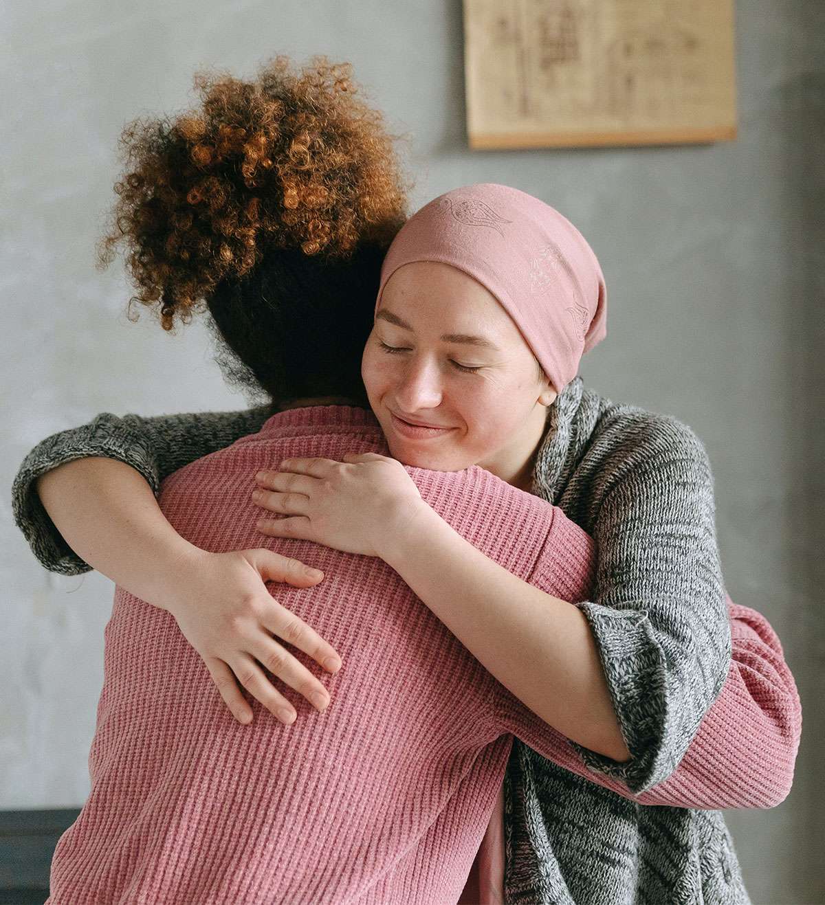 two young women embracing after chemotherapy