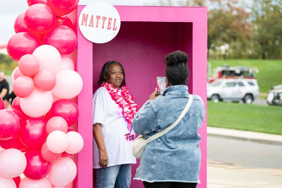 woman getting her picture taken inside pink photo booth