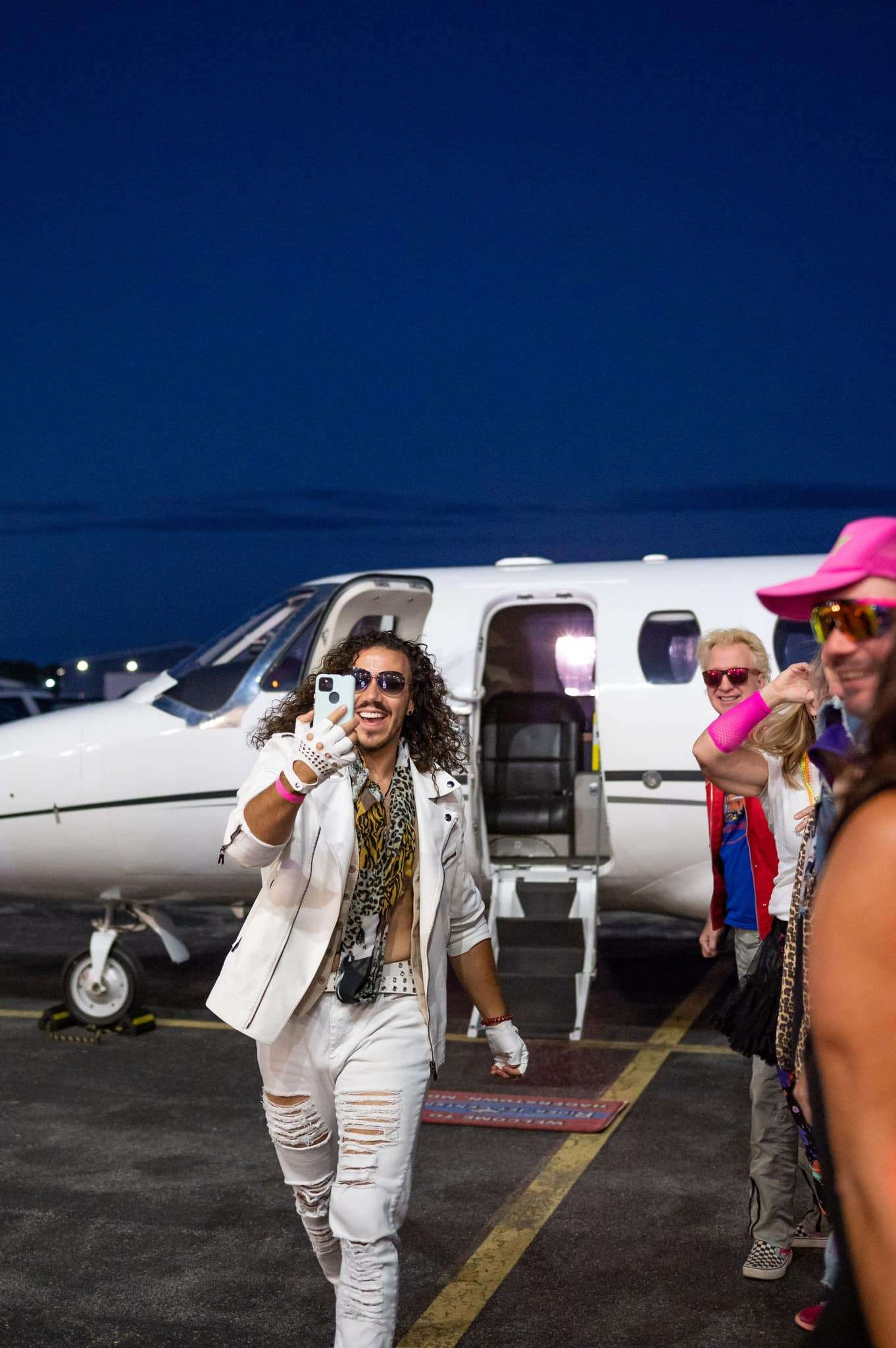 stylish man exiting a private jet while taking a selfie